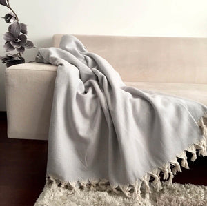 This beautiful throw blanket is hand loomed in a light gray herringbone pattern with 100% Turkish Cotton. Known for its softness, comfort, light weight, hypoallergenic, and antimicrobial properties. Can be used as a throw blanket on a bed, couch, picnic, or even at the beach! Get ready to stay warm and comfy! Fair trade. Measure 71"x 94.5". XL King size.  Perfect snuggle on the couch!